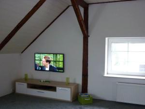 - un salon avec une télévision murale et une fenêtre dans l'établissement Holiday apartment near beach, à Steinhude