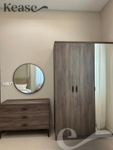 a mirror and a wooden dresser in a room at Kease Al-Mutamarat A-6 Timeless History XZ37 in Riyadh
