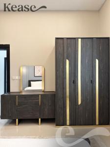 a dressing room with a mirror and a wooden cabinet at Kease Al-Mutamarat A-5 Timeless History AG76 in Riyadh