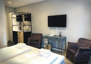 a room with two chairs and a desk and a tv at Älvsjö stadshotell in Stockholm