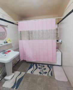 a bathroom with a pink shower curtain and a sink at Dar mima baya in Tunis