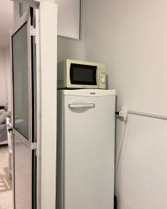 a microwave sitting on top of a refrigerator at Al Rio in Gualeguaychú +3 photos