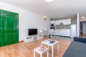 Il comprend un salon avec une porte verte et une cuisine. dans l'établissement Fantástico apartamento con terraza y vistas al mar, à Costa Teguise