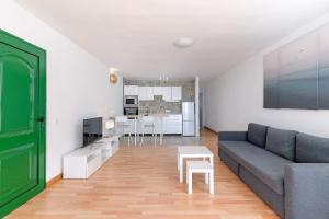 un salon avec un canapé et une table dans l'établissement Fantástico apartamento con terraza y vistas al mar, à Costa Teguise