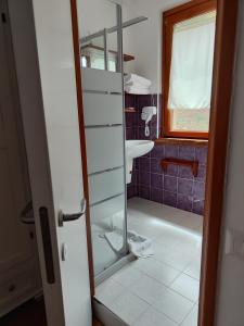 baño con lavabo y puerta de ducha acristalada en Agriturismo Scialà, en Serramezzana