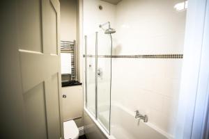 a bathroom with a shower with a glass door at The Lazy Goose - Coffee House & Bedrooms in Stonehouse