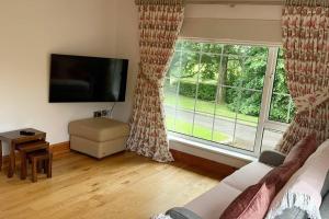 a living room with a couch and a large window at Mountain Nest at the foot of Slieve Gullion in Cloghoge