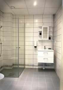 a bathroom with a glass shower and a sink at Älvsjö stadshotell in Stockholm