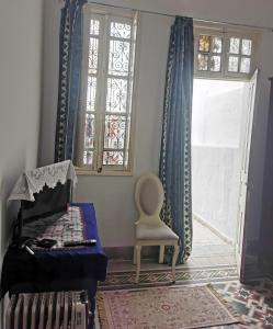 a living room with a chair and a window at Dar mima baya in Tunis