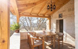 een eetkamer in de openlucht met een houten tafel en stoelen bij 2 Bedroom Amazing Home In Obrovac Sinjski in Obrovac Sinjski