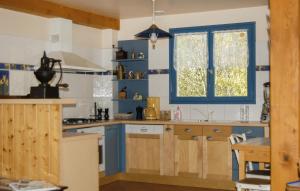 eine Küche mit blauen Schränken und einem Fenster in der Unterkunft 4 Bedroom Stunning Home In Louvie-juzon in Louvie Juzon