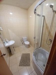 een badkamer met een douche, een toilet en een wastafel bij Prometey Hotel in Dniprodzerzhynsʼk