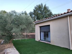 une maison avec une cour avec de l'herbe verte dans l'établissement Maison jardin privatif au coeur d'une oliveraie, à Roquevaire