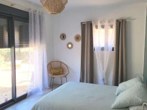 - une chambre avec un lit, une fenêtre et une chaise dans l'établissement Maison jardin privatif au coeur d'une oliveraie, à Roquevaire