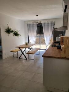 une cuisine avec une table et une salle à manger dans l'établissement Maison jardin privatif au coeur d'une oliveraie, à Roquevaire