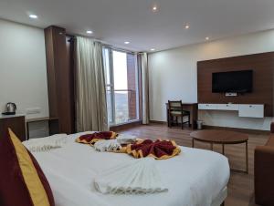 Habitación de hotel con cama grande y TV en OXYRICH, en Madikeri