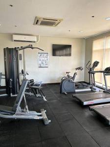a gym with several treadmills and exercise bikes at Studio near Ayala Vertis North in Manila