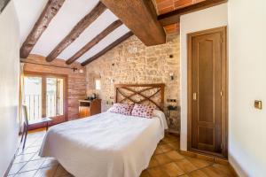 1 dormitorio con 1 cama en una habitación con paredes de piedra en HOTEL EL CASTELL en Valderrobres