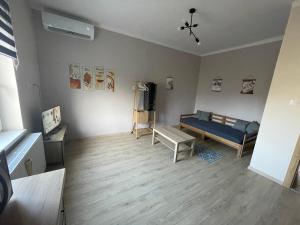 uma sala de estar com uma cama e uma mesa em Liliom Apartman Békéscsaba em Békéscsaba