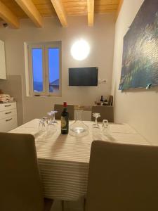 a table with glasses and a bottle of wine on it at Appartamento in Valpolicella (AquardensGardaVerona in Settimo