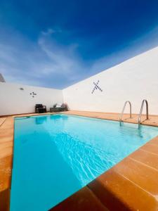 una piscina de agua azul en un edificio en La Asomada Suite Moon Lanzarote, en Tías