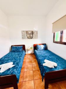 una habitación con 2 camas y una mesa con una pintura en La Asomada Suite Moon Lanzarote, en Tías