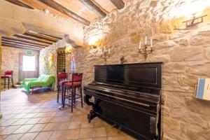 um piano numa sala com uma parede de pedra em HOTEL EL CASTELL em Valderrobres