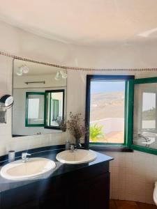 baño con 2 lavabos y espejo grande en La Asomada Suite Moon Lanzarote, en Tías