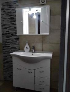 W łazience znajduje się biała umywalka i lustro. w obiekcie Maria’s apartment w mieście Amfilochia