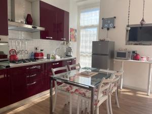 a kitchen with a glass table and chairs in it at Appartamento Piazza Anco Marzio in Lido di Ostia