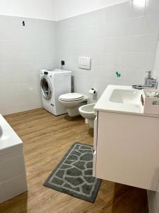 a bathroom with a toilet and a washing machine at Ophelia Leon Charme&Relax in Bergamo