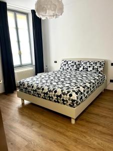 a bedroom with a bed with a black and white comforter at Ophelia Leon Charme&Relax in Bergamo