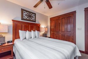 1 dormitorio con 1 cama blanca grande y cabecero de madera en A215 One Bedroom Lake View, en Oakland