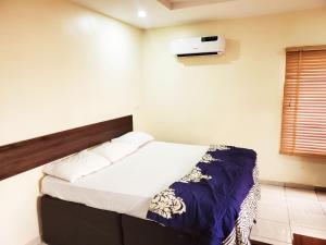 a bedroom with a bed and a air conditioner on the wall at Central District Apartment (Abuja) in Aso
