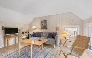 uma sala de estar com um sofá e uma mesa em Beautiful Home In Fan With Wi-fi em Fanø