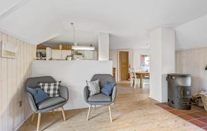 a living room with two chairs and a stove at Beautiful Home In Fan With Wi-fi in Fanø