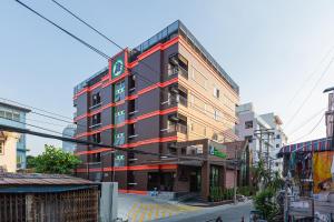 ein Gebäude mit roten Streifen auf der Seite in der Unterkunft โรงแรมเซเว่นรัชดา S7VEN RATCHADA in Ban Na Song