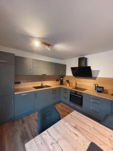 een keuken met blauwe kasten en een houten aanrecht bij Spessart Chalet in Dammbach
