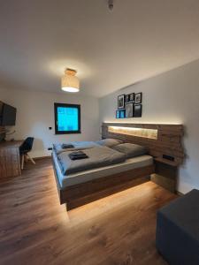 een slaapkamer met een groot bed en een bureau bij Spessart Chalet in Dammbach