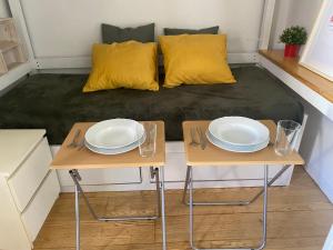 Habitación pequeña con 2 mesas con platos. en Apartamento en el casco antiguo, en Madrid