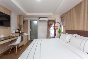 Habitación de hotel con cama grande y cocina en โรงแรมเซเว่นรัชดา S7VEN RATCHADA, en Ban Na Song
