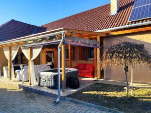 a house with a pergola with a red couch at Holiday home in Kereki - Balaton 48110 in Kereki