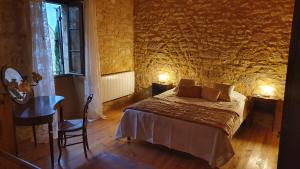1 dormitorio con cama, mesa y ventana en Maison Domme Dordogne, en Domme