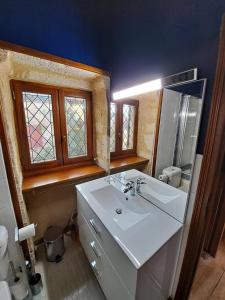 y baño con lavabo blanco y espejo. en Maison Domme Dordogne en Domme
