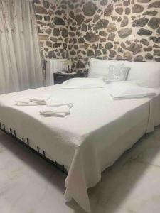 1 dormitorio con 1 cama grande con sábanas y almohadas blancas en Lovely Apartment in Litoxoro en Litóchoron
