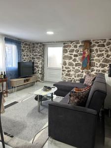 sala de estar con sofá y pared de piedra en Lovely Apartment in Litoxoro en Litóchoron