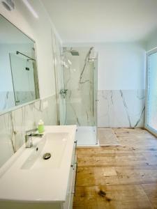 a bathroom with a white sink and a shower at Apartamenty Spacerowa 27 in Niechorze