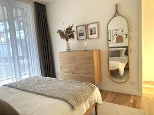 a bedroom with a dresser and a mirror at Stylishly Decorated Apartment at Berlin Wall in Berlin