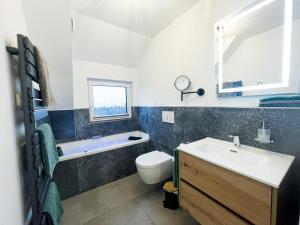 ein Badezimmer mit einem Waschbecken, einem WC und einer Badewanne in der Unterkunft Ferienhaus Waldzauber-Winterberg in Winterberg