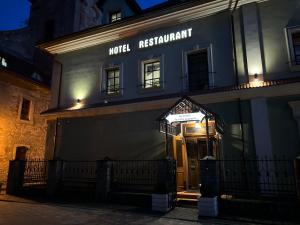 a night view of a hotel restaurant with a door at U Dominicana in Kamianets-Podilskyi